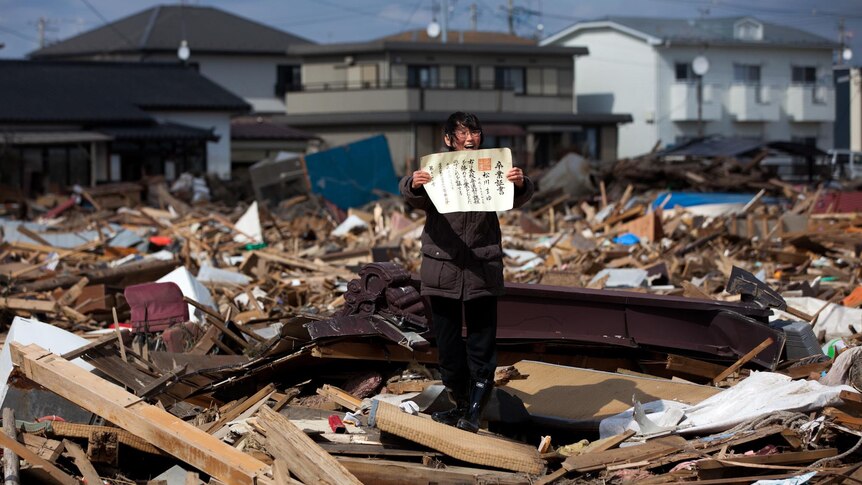 Chieko Matsukawa shows her daughter’s graduation certificate as she finds it in the tsunami debris.