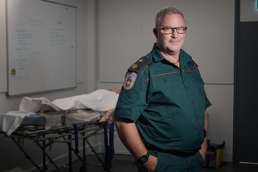 a middle-aged man wearing a green paramedics uniform