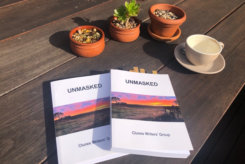 Two copies of the book titled Unmasked" On a table