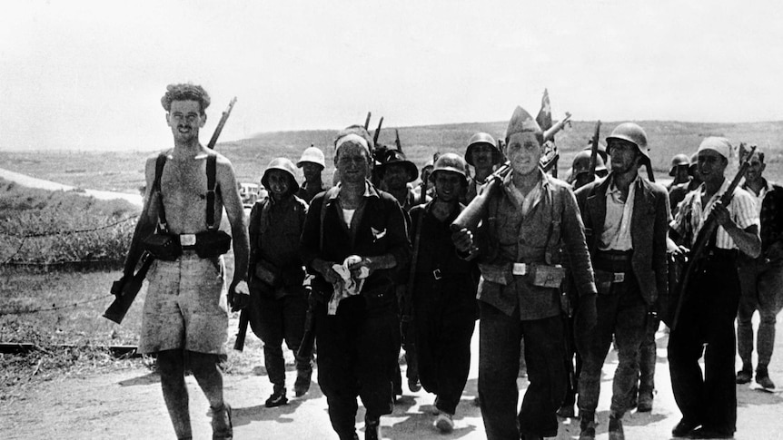 A line of civilian soldiers, out of uniform march along the road in Spain 1936, members of the German Thalmann Brigade