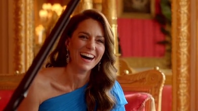 Kate Middleton sits in a blue dress whilst playing piano.