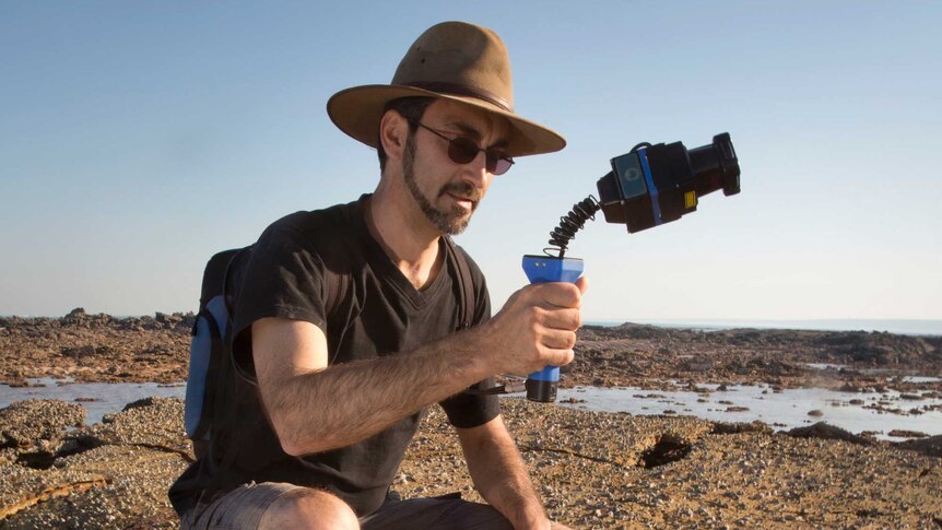 Researcher Anthony Romilio with a Zebedee, a laser scanner used to create 3D images of the dinosaur trackways.
