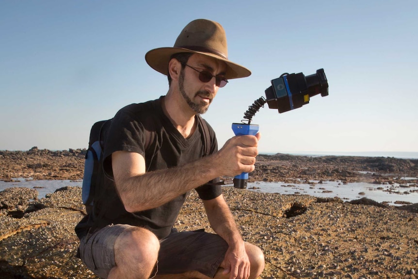 Researcher Anthony Romilio with a Zebedee, a laser scanner used to create 3D images of the dinosaur trackways.