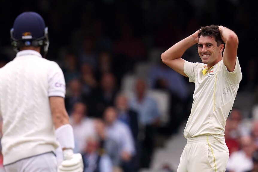 Australia bowler Pat Cummins puts his hands on his head as an England batter looks at him during an Ashes Test.