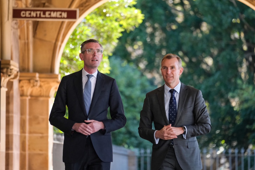 Two men dressed in suits walking and talking 