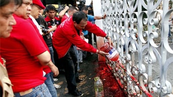 Red Shirt supporters of former prime minister Thaksin Shinawatra pour human blood on gates of the Thai parliament in Bangkok ...