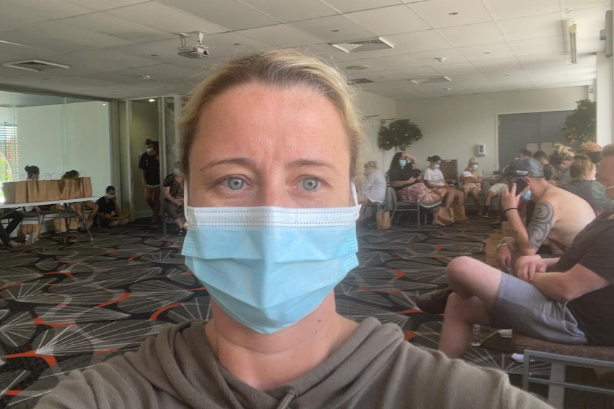 A blonde woman wearing a surgical mask