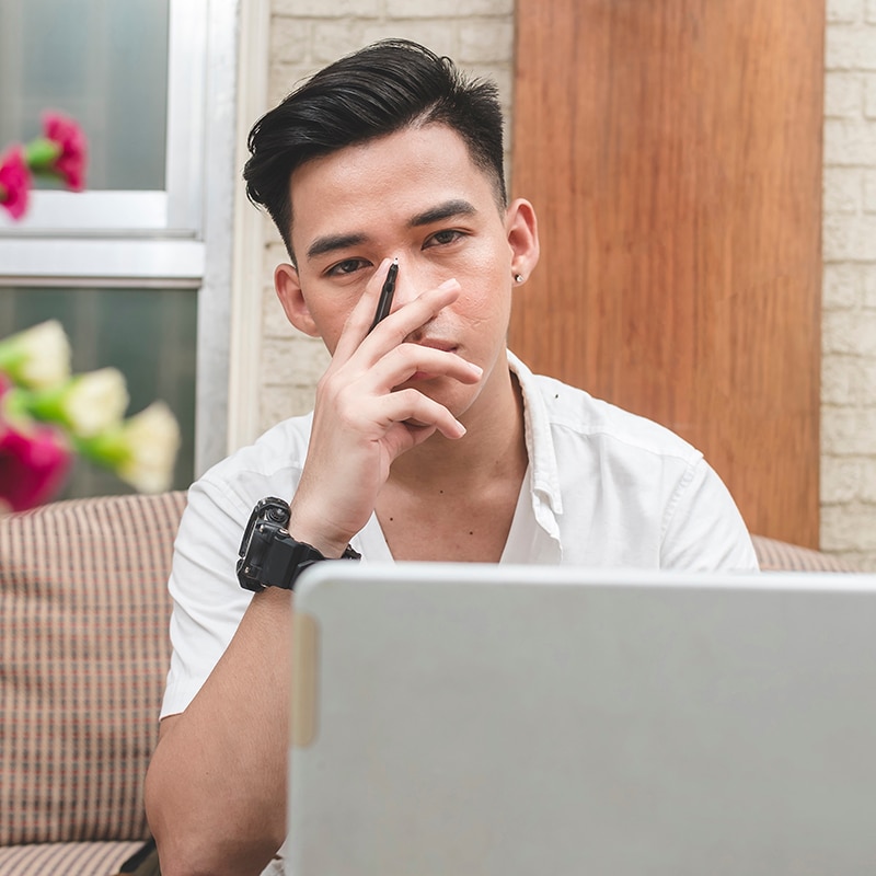 Man in front of laptop looking tired