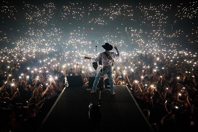 A singer stands on stage in front of big crowd