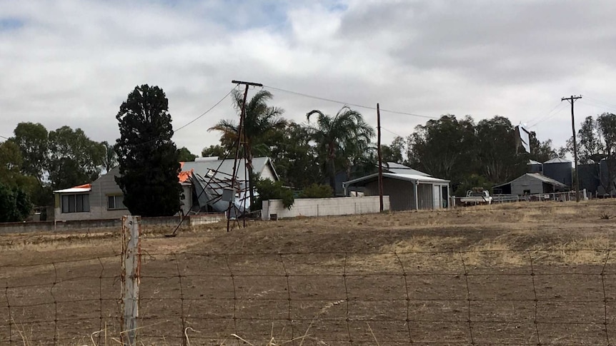 A farmhouse in with part of the roof caved in.