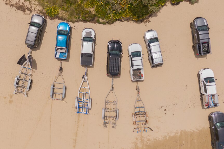 Empty boat trailers on a beach.