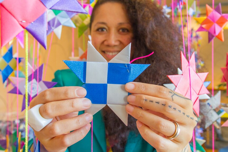 Artist Maryann Tali Pau holds an eight-pointed star.