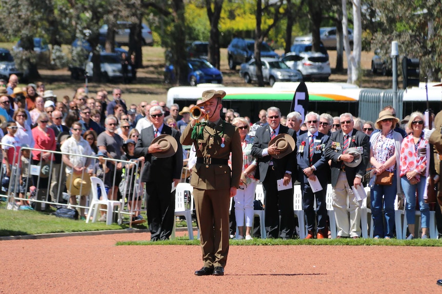 A bugler at the Remembrance Day National Ceremony in Canberra, standing in front of a crowd.
