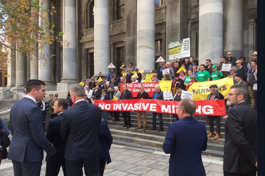 Four Government MPs address a crowd of protesters on the steps of South Australia's Parliament.