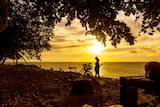 A child watches the sunset on Murray Island in the Torres Strait.