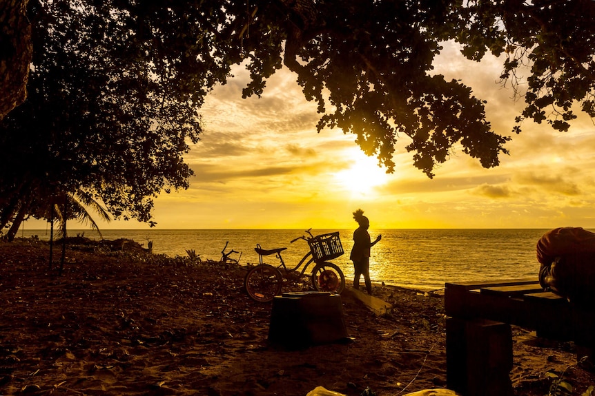 A child watches the sunset on Murray Island in the Torres Strait.