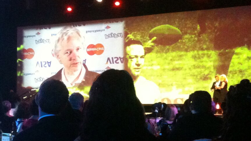 WikiLeaks founder Julian Assange accepts the award for most outstanding contribution to journalism