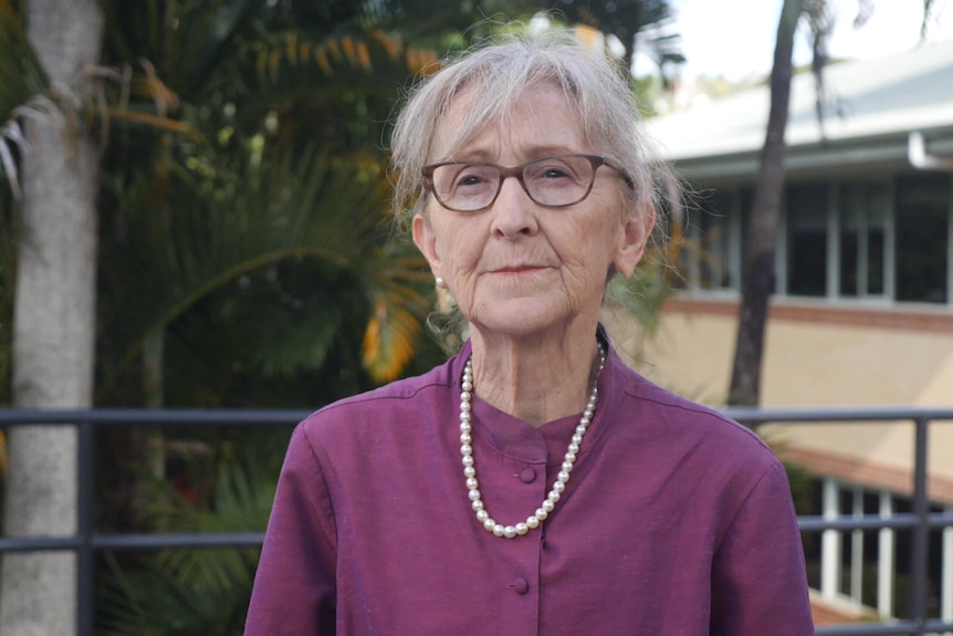 A woman with glasses in a purple shirt