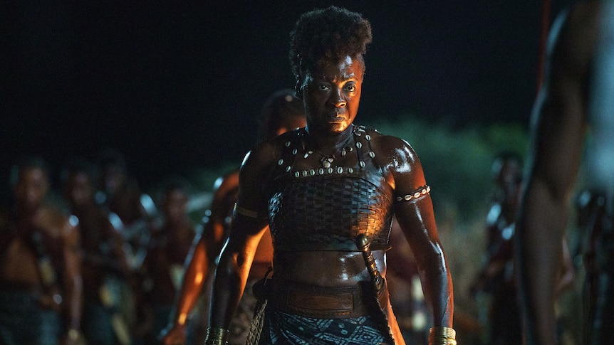 Black woman in stretch-knit fabric, minimalist battle outfit in the dark of night looking poised to fight. 