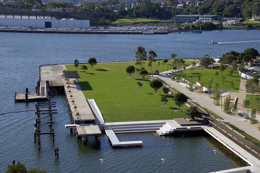 An aerial view of the water showing steps down to the water and a park next to it.