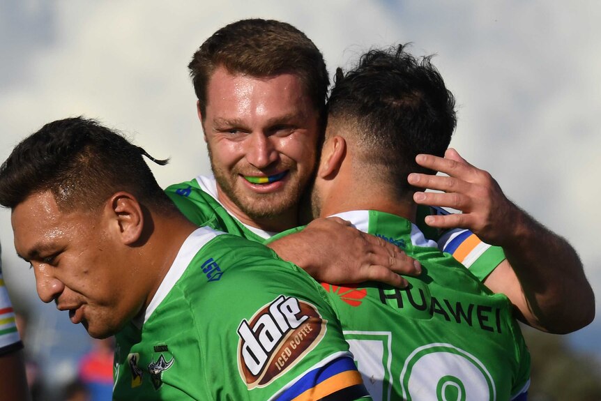 Michael Oldfield smiles as he is hugged by Raiders teammate Ryan Sutton as they celebrate a try against the Panthers.