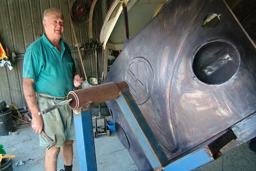 Mitchell Montgomery standing next to the Kombi in the garage.