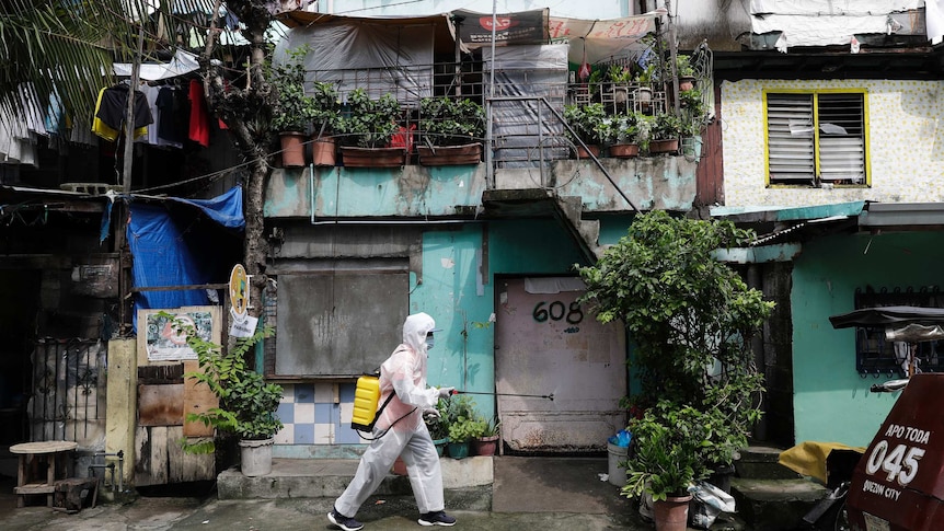 A man wearing a hazmat suit disinfects a slum neighbourhood in Calcoocan city, Philippines.
