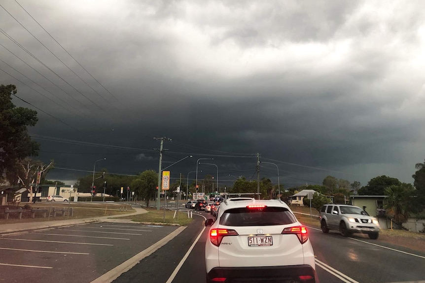 Dark storm clouds over Yamanto at Ipswich, west of Brisbane, with traffic on a road on March 19, 2019.