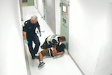 Jia Meeks is held down by a Victoria Police officer while in custody after he was thrown to the ground.