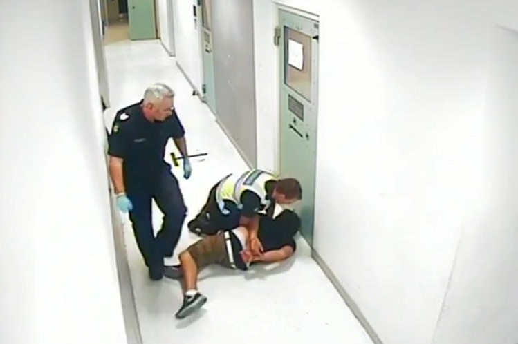 Jia Meeks is held down by a Victoria Police officer while in custody after he was thrown to the ground.