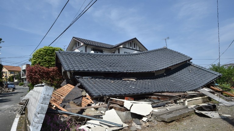 A damaged house with a flattened roof.