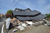 A damaged house with a flattened roof.