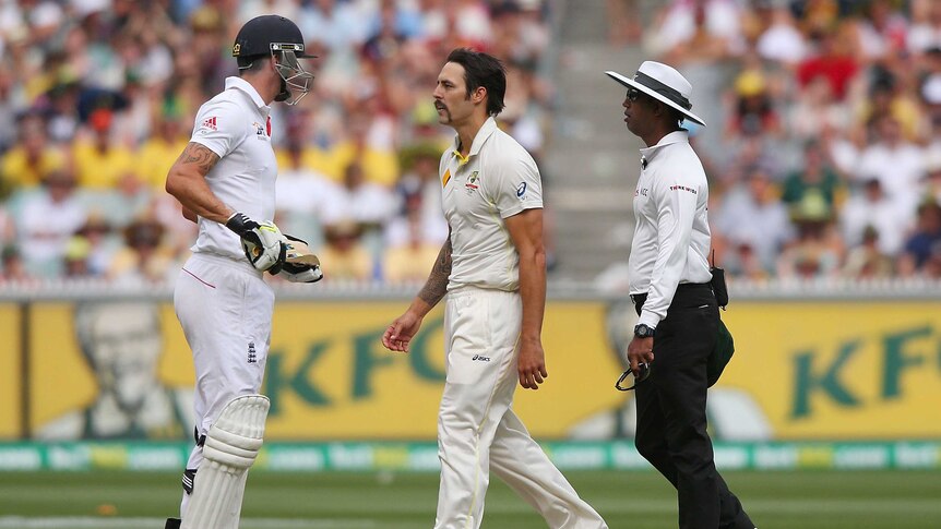 England's Kevin Pietersen (L) and Australia's Mitchell Johnson clash on day three at the MCG.