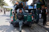 Afghan policemen arrive at the site of a rocket-propelled attack in Kabul.