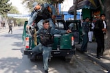 Afghan policemen arrive at the site of a rocket-propelled attack in Kabul.