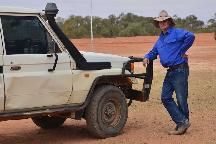 Far West grazier Lachlan Gall leaning on a ute in outback NSW