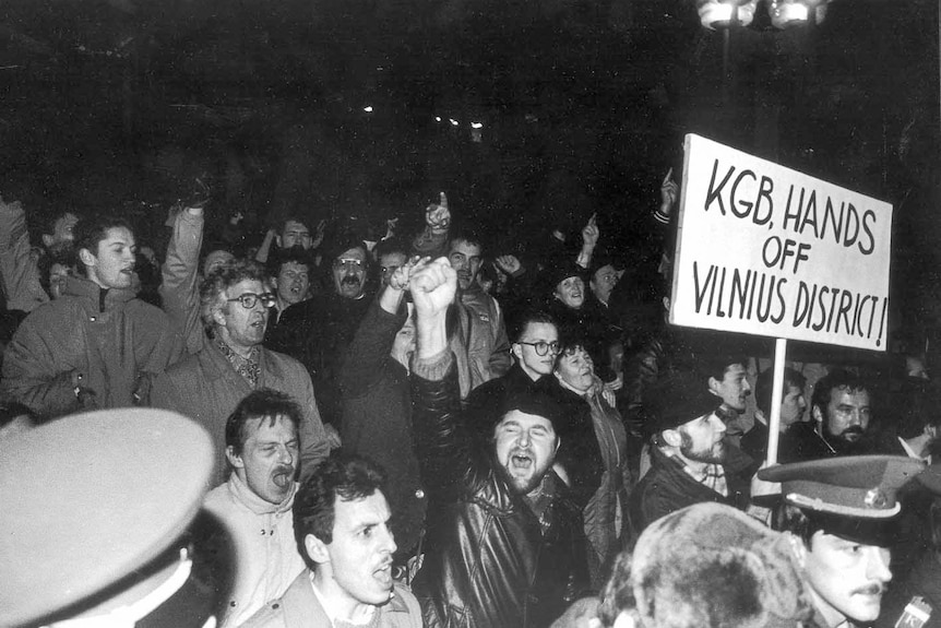 A black and white photo f a protesting crowd One sign reads 'KGB hands off Vilnius district'