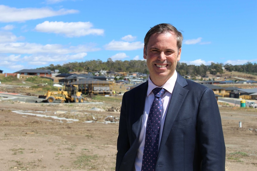 Brian Wightman, a man in a dark suit, stands on a building site