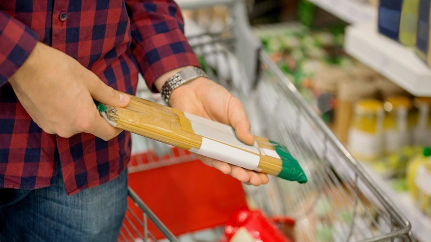 Man buying pasta in supermarket