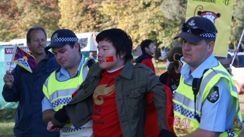 Police escort a pro-China protester