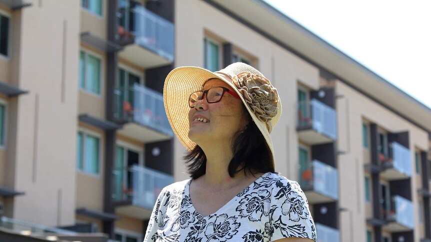 A photo of Veronica Lam looking up towards the sun in Darwin city.