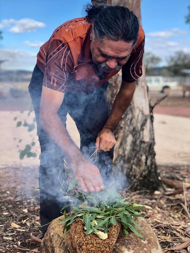 A man performs an Aboriginal smoking ceremony.
