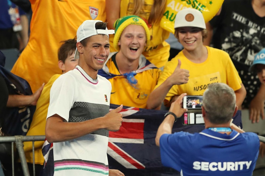 Australian player is surrounded by happy fans after his second round win at Melbourne Park.
