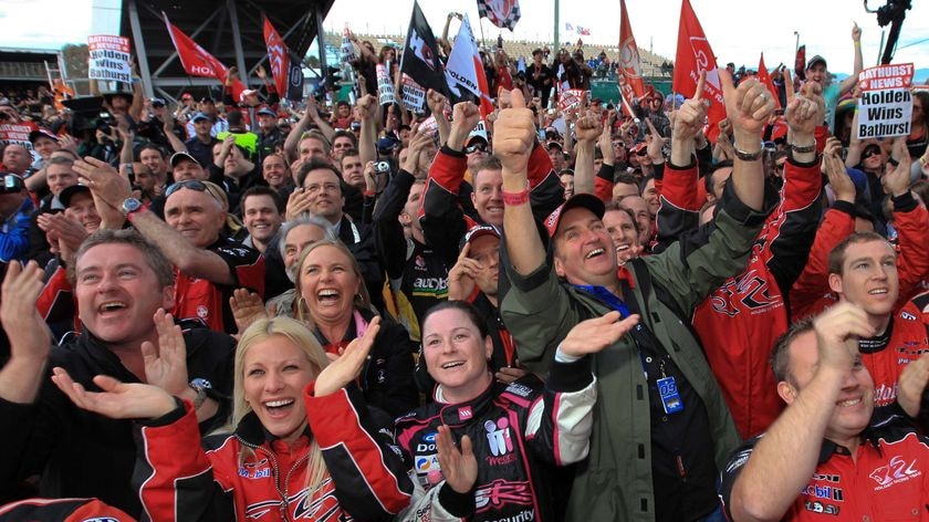 Holden Racing Club fans cheer in red t shirts.