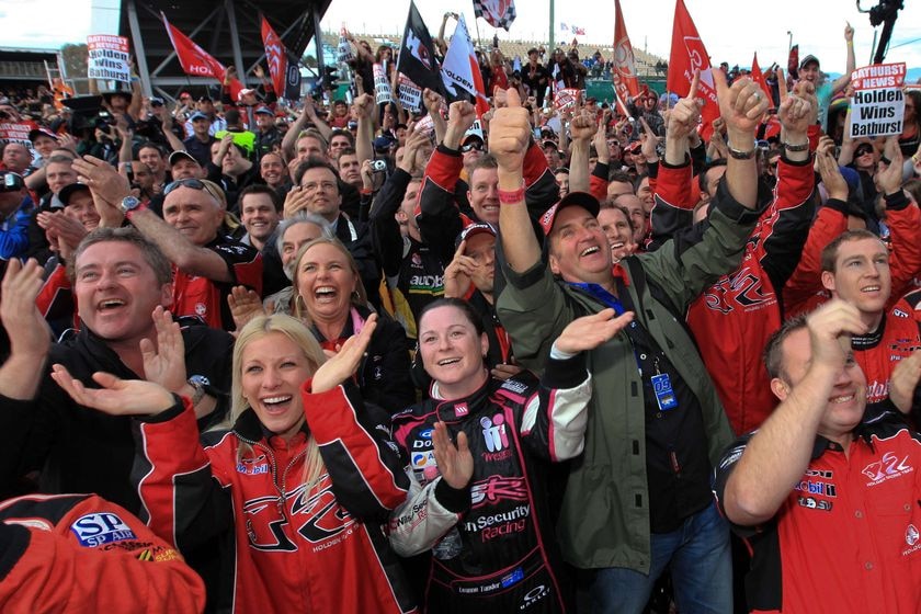 Holden Racing Club fans cheer in red t shirts.