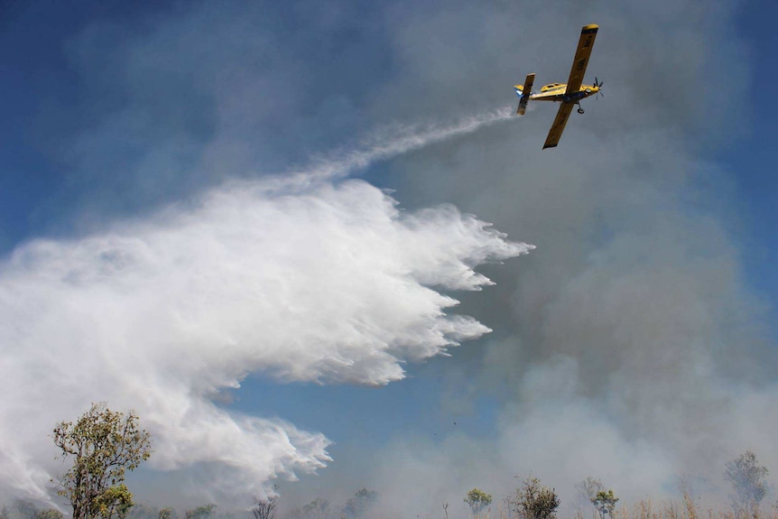 A plane dumps water on a fire.