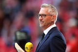 Soccer broadcaster Gary Lineker holding a microphone 