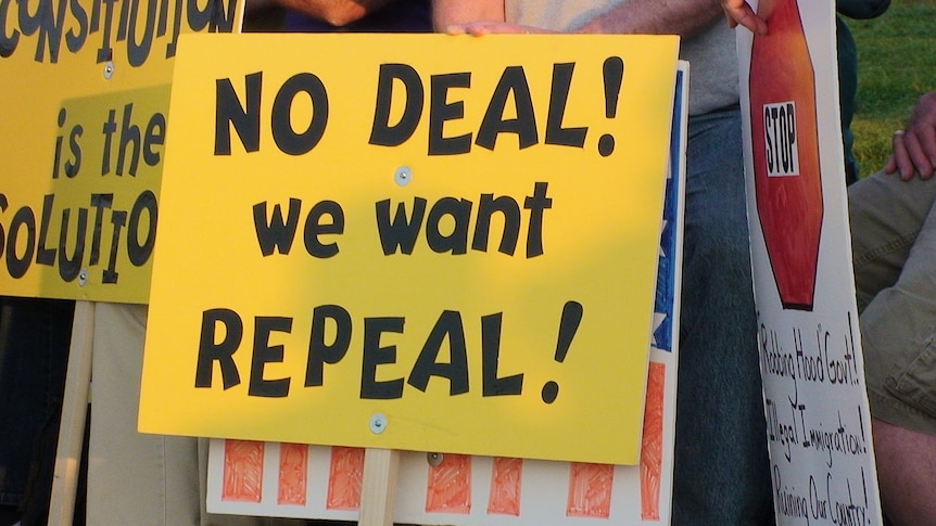 A bright yellow sign warning against President Obama's Affordable Care Act reads 'No Deal! We want repeal!'
