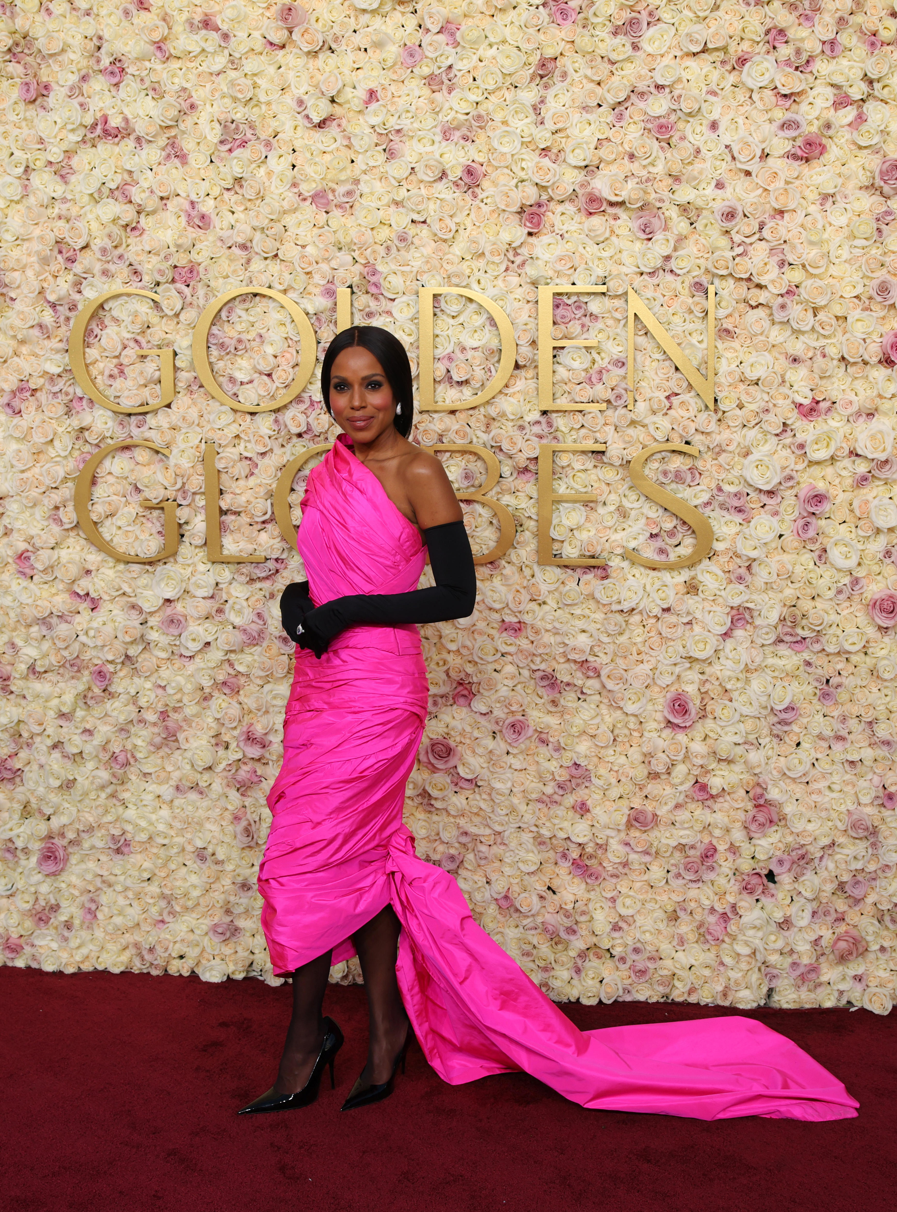 Kerry Washington wears a neon pink one-shoulder dress with a train 