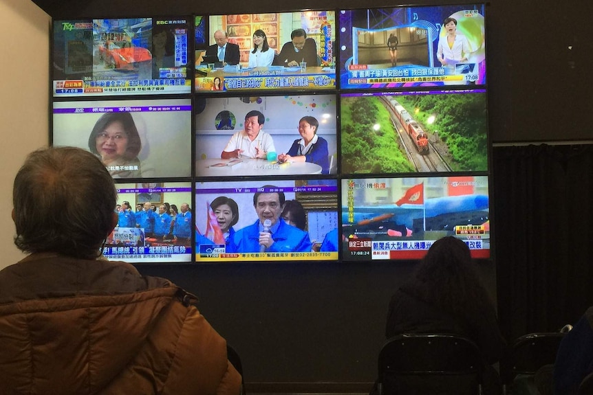 People watch political television shows at DPP headquarters in Taipei